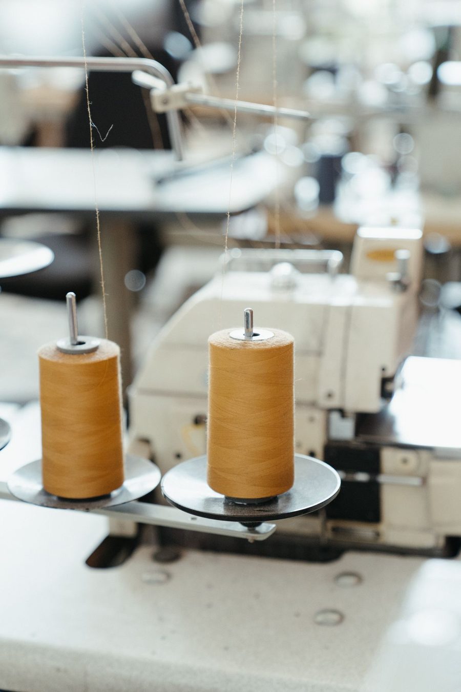 Spools of ochre thread on a sewing machine